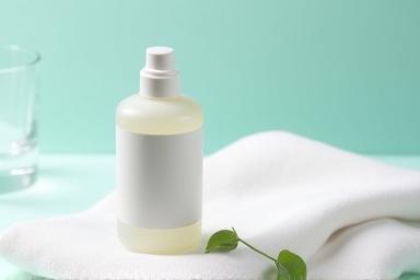 A small, concentrated bottle of Herbal Gleam Herbal Stain Remover, alongside a pristine fabric swatch.